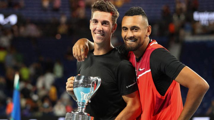Australia's Thanasi Kokkinakis (L) and compatriot Nick Kyrgios pose with the trophy after winning against Australia's Matthew Ebden and compatriot Max Purcell during their men's doubles final match on day thirteen of the Australian Open tennis tournament in Melbourne on January 29, 2022. (Photo by Aaron FRANCIS / AFP) / -- IMAGE RESTRICTED TO EDITORIAL USE - STRICTLY NO COMMERCIAL USE --