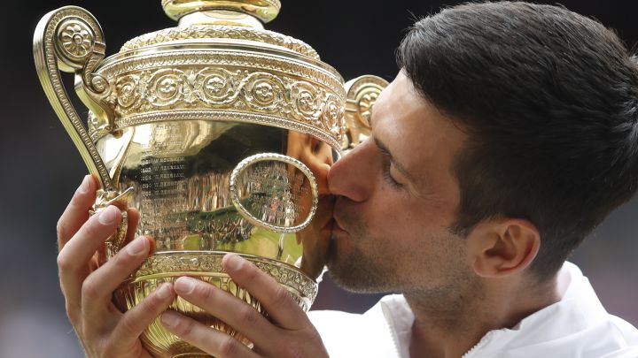 Serbian tennis player Novak Djokovic kisses the 2021 Wimbledon champion trophy after beating Matteo Berrettini in the final.