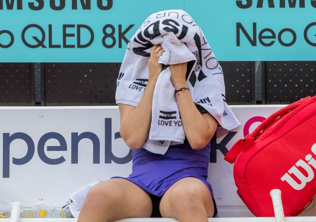 Paula Badosa covers her face during a break.