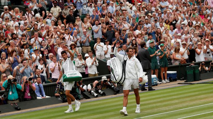 Novak Djokovic of Serbia and Rafa Nadal of Spain greet the crowd on Center Court after their 2018 Wimbledon semifinal match.