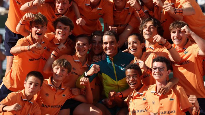 Spain\'s Rafael Nadal poses ballboys as he celebrates after victory over Norway\'s Casper Ruud during their men\'s singles final match on day fifteen of the Roland-Garros Open tennis tournament at the Court Philippe-Chatrier in Paris on June 5, 2022. (Photo by Thomas SAMSON / AFP)