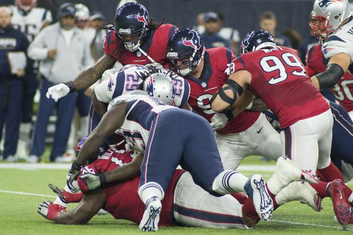 La defensa de Houston Texans, con J. J Watt ala acabeza, parando a Legarrette Blount en un Patriots contra Texans.