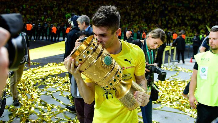 Dortmund's US midfielder Christian Pulisic celebrates with the trophy after victory during the German Cup (DFB Pokal) final football match Eintracht Frankfurt v BVB Borussia Dortmund at the Olympic stadium in Berlin on May 27, 2017. / AFP PHOTO / Tobias SCHWARZ / RESTRICTIONS: ACCORDING TO DFB RULES IMAGE SEQUENCES TO SIMULATE VIDEO IS NOT ALLOWED DURING MATCH TIME. MOBILE (MMS) USE IS NOT ALLOWED DURING AND FOR FURTHER TWO HOURS AFTER THE MATCH. == RESTRICTED TO EDITORIAL USE == FOR MORE INFORMATION CONTACT DFB DIRECTLY AT +49 69 67880