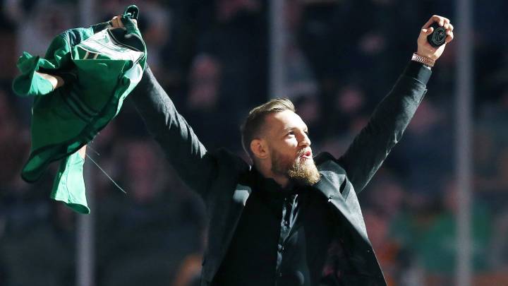 Conor McGregor salutes the crowd before making the ceremonial puck drop at an NHL hockey game between the Boston Bruins and the Columbus Blue Jackets in Boston