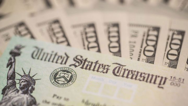 Cuarto cheque de estímulo de Estados Unidos y billetes de 100 dólares estadounidenses