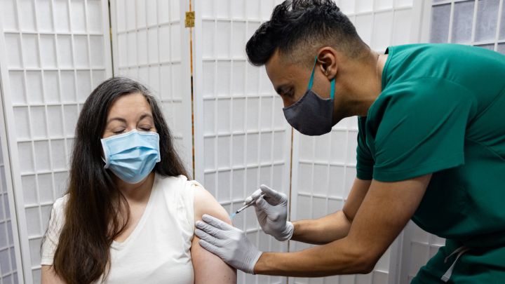 Mujers recibe la vacuna contra COVID-19 