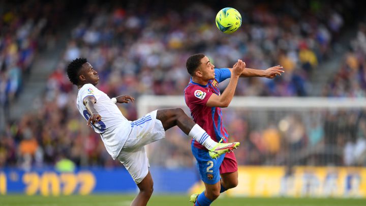 Sergiño Dest busca cortar un pase con dirección a Vinicius Jr. en Clásico entre el Barcelona y Real Madrid en el Camp Nou.