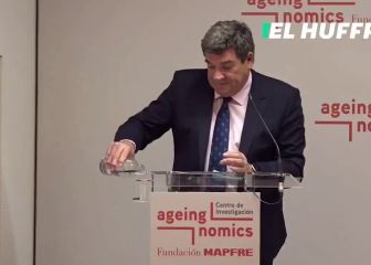 El momento más surrealista del ministro Escrivá: confunde un hueco del atril con un vaso